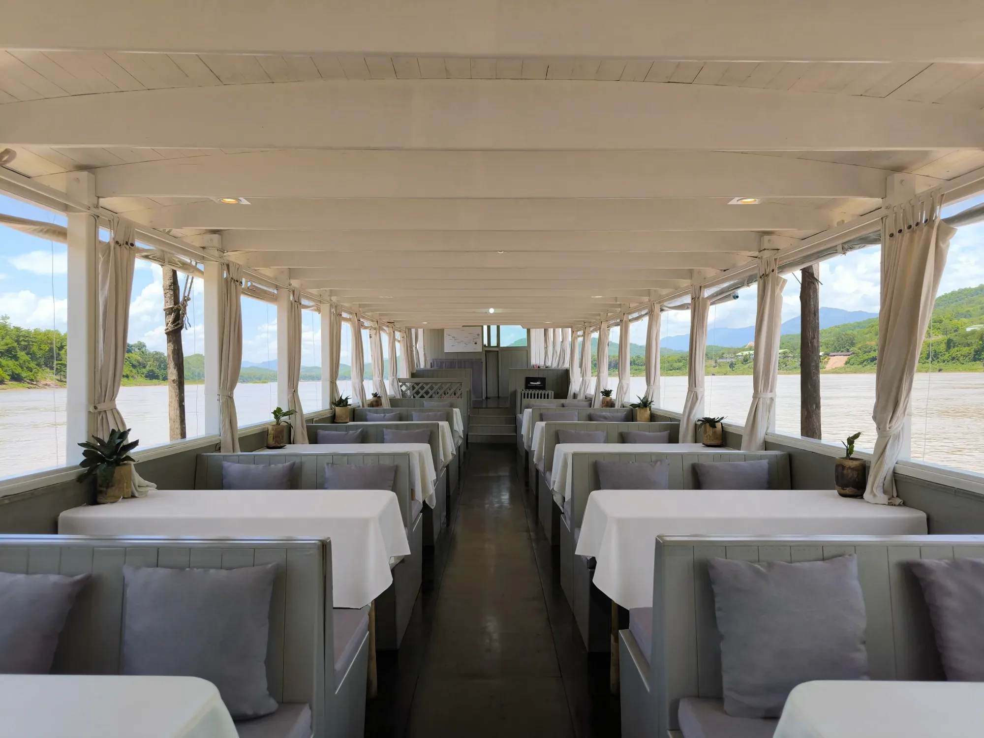 Rows of dining booths down the centre aisle of the Mekong Cruises boat